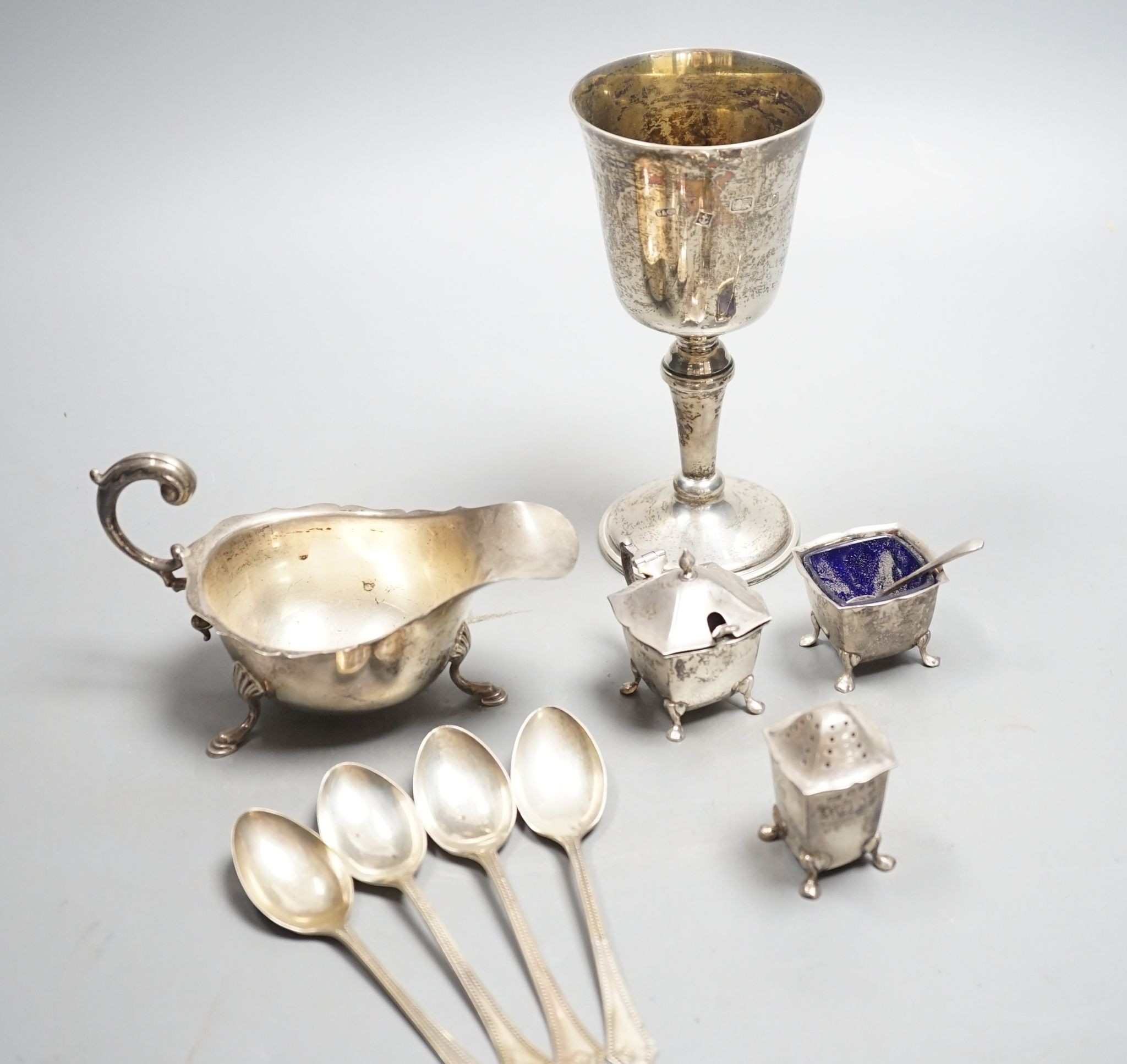 A modern silver goblet, 15.8cm, a silver sauceboat, four silver spoons and three silver condiments, 10.5oz.